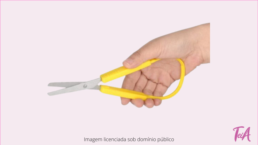 Tesoura com facilitador de encaixe e com elástico para facilitar a preensão.
